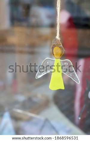               the figure of an angel against the background of a blurry shop window                 
