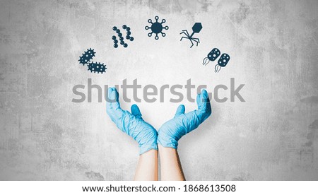 Hands raised up with germs, coronavirus and bacteria icons. The concept of protection against viruses, bacteria.
