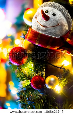snowman with christmas lights in the background