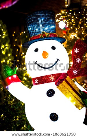 snowman with christmas lights in the background