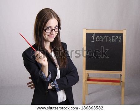 Portrait of the teacher. In the hands of the teacher's pointer. The teacher in the background stands the Board where it is written on September 1