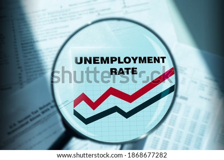 Unemployment rate graph is increasing. Inscription unemployment rate under a magnifying glass. Growth in unemployment. Crisis in the labor market. Graph shows an increase in layoffs. Statistics Royalty-Free Stock Photo #1868677282