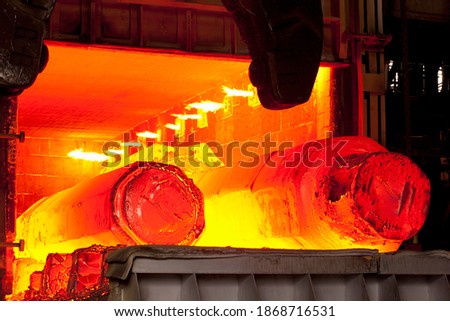 A medium shot of two hot molten forged steel rods in a furnace. Royalty-Free Stock Photo #1868716531