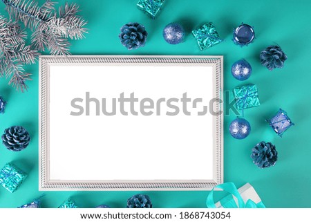 Photo frame with free white space around Christmas tree decorations and gifts on a blue background.