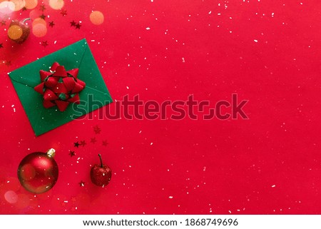 Christmas letter with greeting card and congratulations, christmas tree branches, baubles, glitter decorations on red surface. Flat lay, banner, copy space