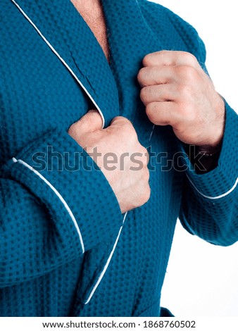man in a bright, bath robe advertises clothing details on an isolated white background. Taken in the Studio close-up.