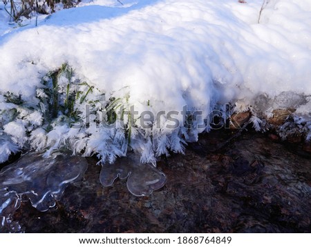Stunning frozen icicles waterfall on a rocky mountain cliff on a winter day. The winter cascade is frozen in numerous white icicles. Waterfall falling past hundreds of icicles fantastic winter landsca