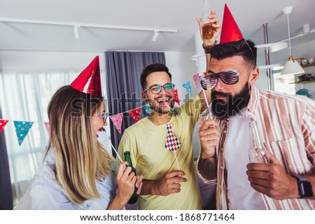 Group of happy people celebrating birthday among friends and smiling while having a party