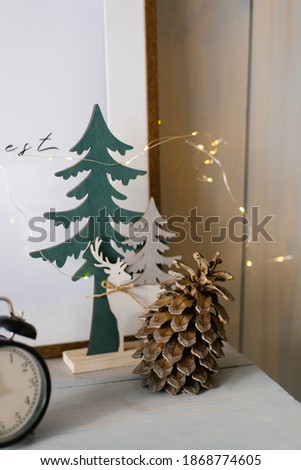Christmas card. Wooden Christmas tree and pine cone with garland