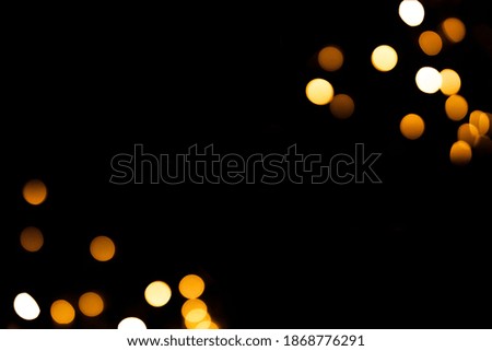Bright yellow blurry lights on a black background. Bokeh for post-processing photos, design.