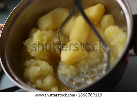 potatoes being mashed in stainless steel saucepan close up Royalty-Free Stock Photo #1868789119