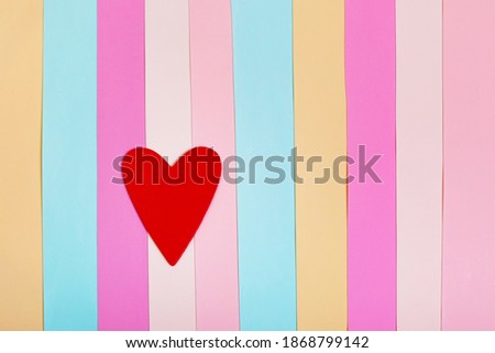 Red heart on a multicolored striped background. For web design, postcard, banner. Valentine's Day, Wedding, Birthday, International Women's Day. Copy space.