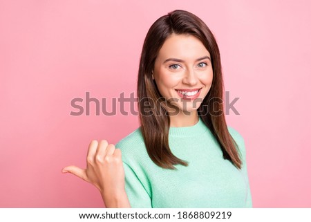 Photo of cheerful pretty girl indicate thumb empty space wear teal pullover isolated pink color background