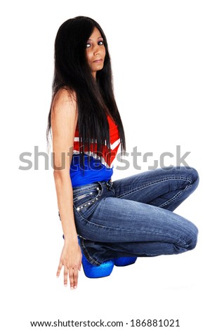 A young pretty Hispanic woman crouching on the floor, isolated for  white background. 