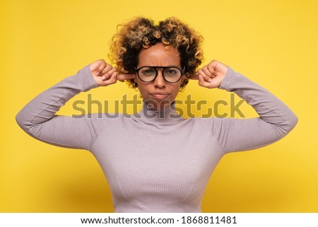 Stressed frustrated young african woman plugging her ears with fingers can not stand terrible noise around her