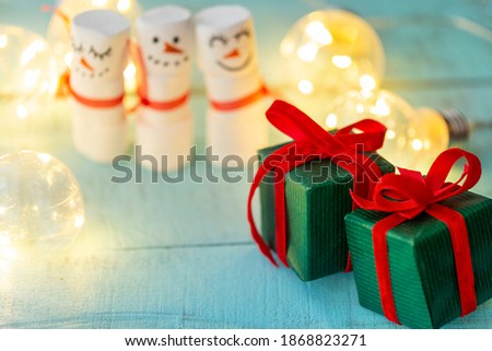decorative gifts with ribbons on the background of blurred marshmallow snowmen, Christmas blurred background with gifts in boxes