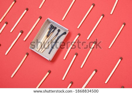 pattern of matches and a box of burnt matches on a red background