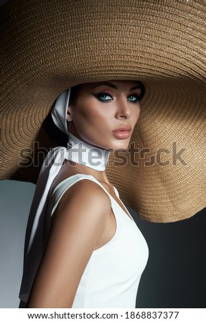 Beauty woman in a large wicker hat and light summer dress. Smokey makeup, perfect portrait of a woman Royalty-Free Stock Photo #1868837377