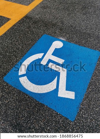 Road sign for the disabled on the asphalt of the road surface.