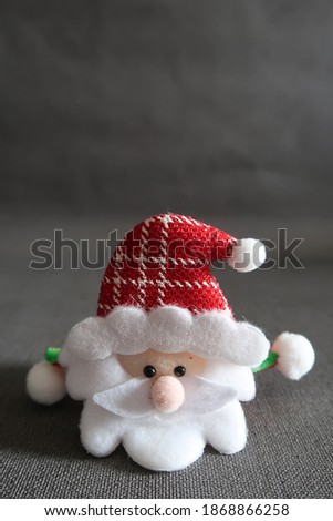 Closeup of cute Santa Claus face on dark background with copy space, concept of Christmas holiday season happiness and festive party