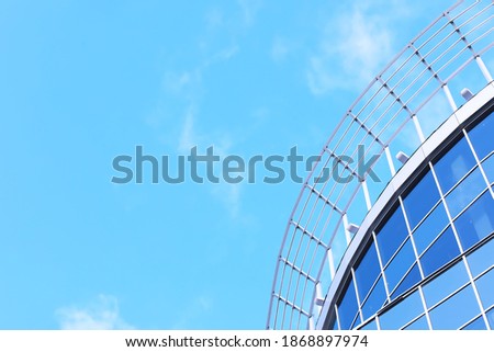 Architectural detail of the facade with multiple reflections of other buildings and the sun. Exterior of modern building. Architecture abstract background