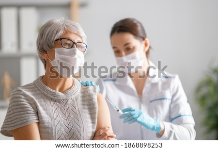 Doctor giving a senior woman a vaccination. Virus protection. COVID-2019. Royalty-Free Stock Photo #1868898253