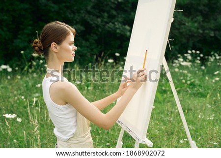 woman outdoors painting a picture landscape hobby