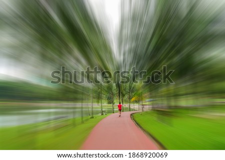 People can seen jogging in the garden in motion blur.