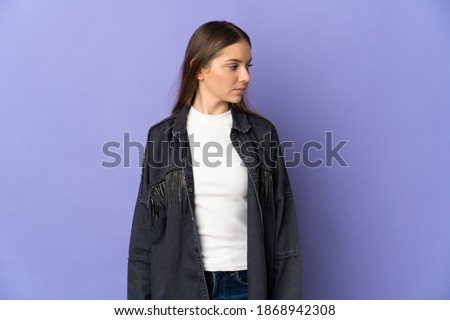 Young Lithuanian woman isolated on purple background looking to the side