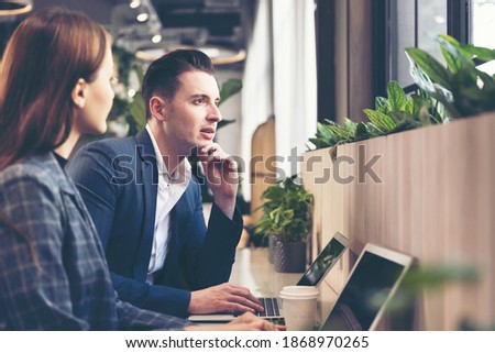 Business young people partner woman and businessman present and start up new project to success together indoor modern nature office.  Woman and man drinking coffee and discuss business. 