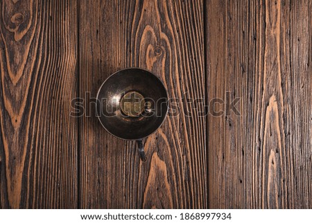 Low key photography- metal coffee cup on wooden background