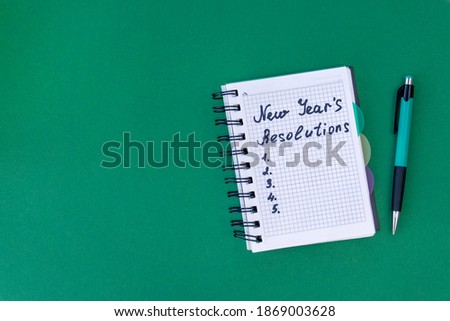 New Year's resolutions concept. New Year's resolutions on a green background. Flat lay. Top view