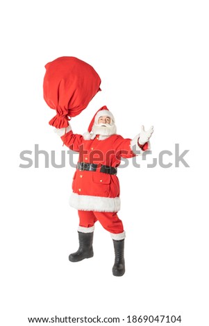 Santa Claus holds with one hand a huge bag of gifts, on an isolated white background. Santa claus in full growth, greeting.