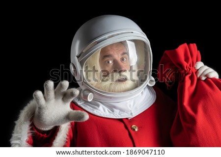 Santa Claus in space, floating in zero gravity. Space Santa levitation. Black background. Royalty-Free Stock Photo #1869047110