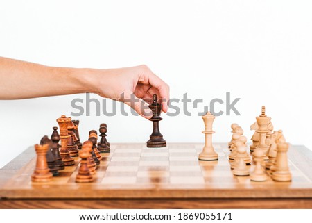 man holds a chess piece with his hand. Chess board. game of chess on a white background. chess tournament