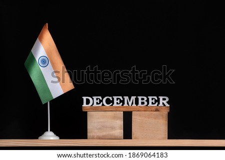 Wooden calendar of December with flag of India on black background. Winter holidays in India