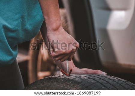 Repair Tires Recap patch a tyre ,Flat tire The tire is leaking from the nail Can a Tire be Repaired by self,Patch on a Punctured Tire Royalty-Free Stock Photo #1869087199