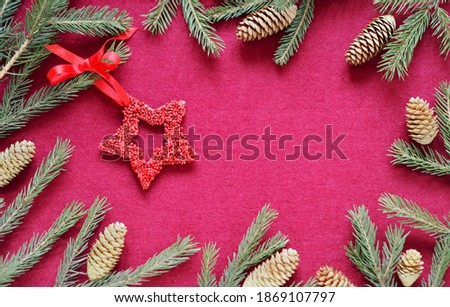 New Year's congratulatory background with New Year's toys stars on fir branches. Red felt background. Place for text.