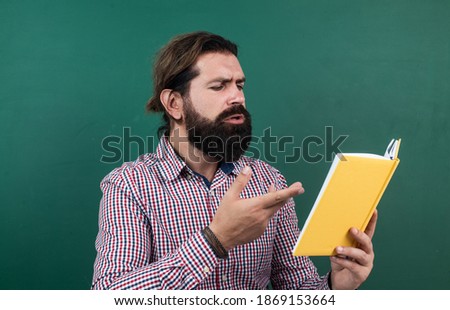 man with beard and moustache look as businessman or teacher in college or school, reading.