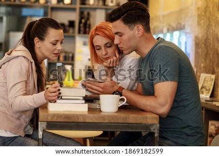 Group of university students hangout in college cafe library and preparing for lecture.	
