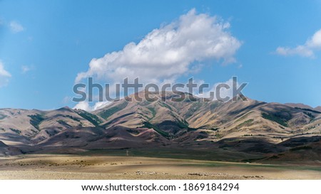Photo of Summer Sandy Hills Landscape. Travel Mountain location of popular tourist attraction. View of beautiful nature Desert on Cloudy Sky Background