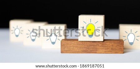 Concept creative idea and innovation. Hand flip over wooden cube block with head human symbol and light bulb icon