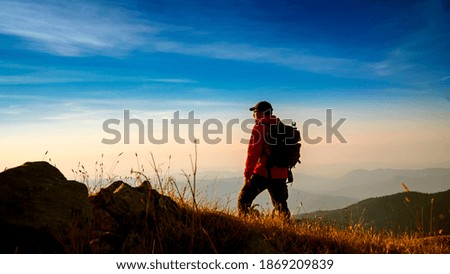 
hiker man walking on mountain at sunset