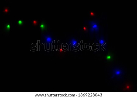 Blurred sparks from fire in front of black backgound. Christmas and New Year holidays concept.  Defocused garland lights, Bokeh effect. 