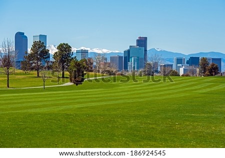 Denver Green Fields, Denver Downtown Skyline and Rocky Mountains Under the Snow. Colorado, United States.