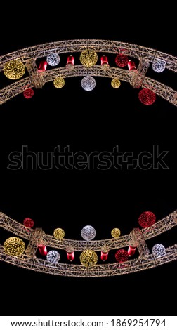 Christmas abstract symmetry frame arch shape decoration object colorful toys and garland lamps on black background empty copy space for your text here vertical picture 