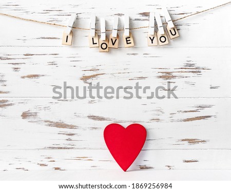 Valentines day red heart shape on white wooden background, inscription from wooden letters.