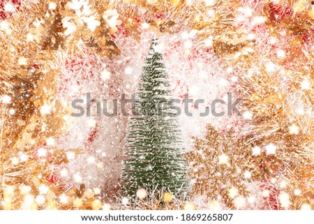 Christmas composition.Small fir, golden bright garlands  on snowflakes background. New year decorations