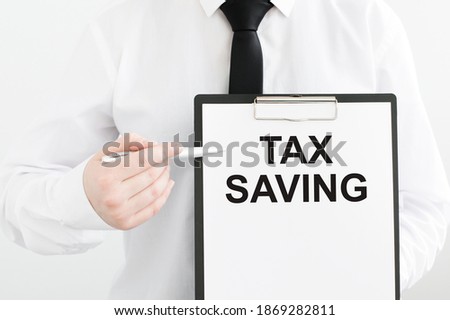 Tax Saving message on the card in the hands of a businessman. Taxes and fees fiscal policies business concept.