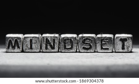 concept of mindset. The inscription on metal 3D cubes isolated on a black background, grunge style